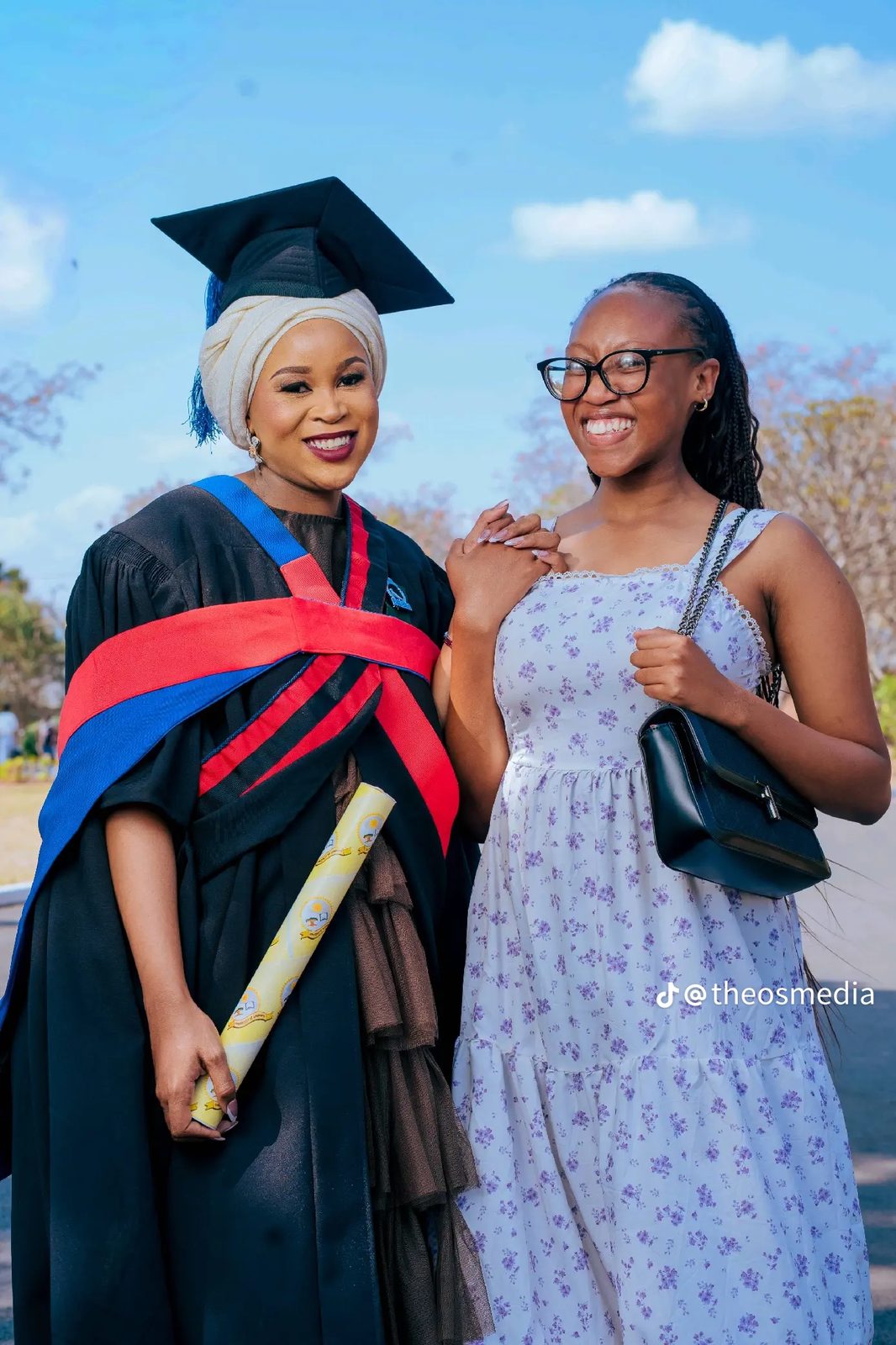 A graduate and a friend smiling together outdoors